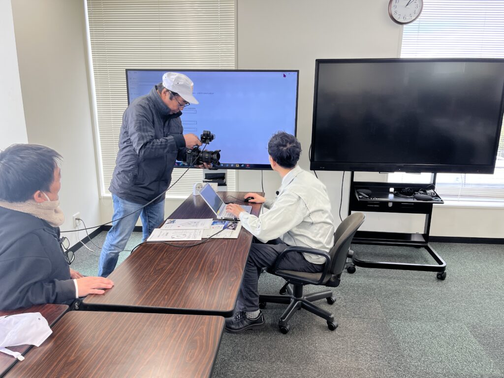 事務所内、インタビューのテレビ取材の撮影風景