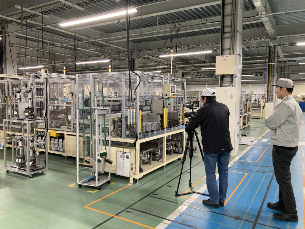 自動車部品の工場内のテレビ取材の撮影風景